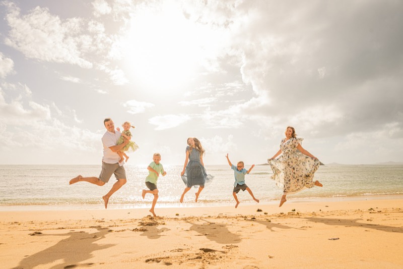 Family jumping on the beach at sunset