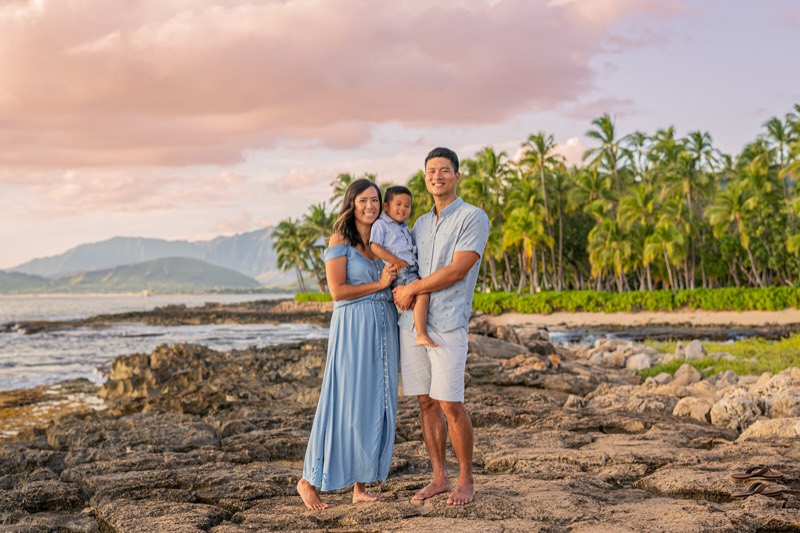 Family of three on the lava rocks at sunset on Oahu, photographed by Toto & Meme